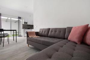 ein Wohnzimmer mit einem Sofa und einem Tisch in der Unterkunft La Corte A2 in Antigua