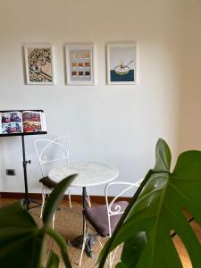 a table and chairs in a room with a plant at Il cantuccio in Ivrea