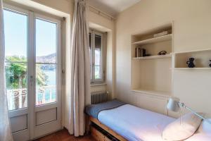 Kleines Zimmer mit einem Fenster und einem Bett mit einem Schreibtisch. in der Unterkunft Meriggi Lakefront by Quokka 360 - lakefront retro house in Caslano in Caslano
