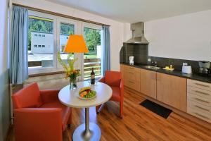 a kitchen with a table with a bowl of fruit on it at Serviced Apartments by Solaria in Davos