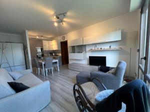 een woonkamer met een bank en stoelen en een keuken bij Comfort e relax ad Abano Terme - Turen in Abano Terme