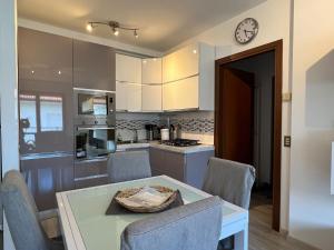 kuchnia ze stołem, krzesłami i zegarem w obiekcie Comfort e relax ad Abano Terme - Turen w mieście Abano Terme