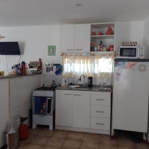 eine Küche mit weißen Schränken und einem weißen Kühlschrank in der Unterkunft La Chichi in Sauce de Portezuelo