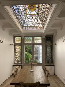 a large room with a table and a stained glass ceiling at Maison Ulysse in Amiens