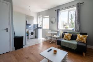 a living room with a couch and a table at Elmcroft Apartment - 10 Mins Walk to Woking Town Centre in Woking