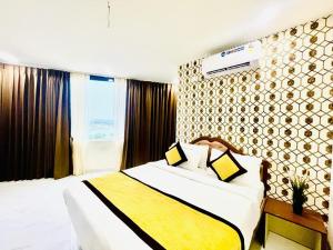 Habitación de hotel con cama con manta amarilla y blanca en HOTEL EAGLE GRAND en Shamshabad