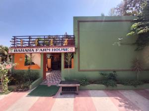 a building with a sign for a farm house at BANANA FARM HOUSE in Hampi