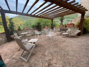 Crocemaroggia的住宿－Il borgo di Firenzuola Camere con camino，一个带桌椅的庭院和一个木制凉亭