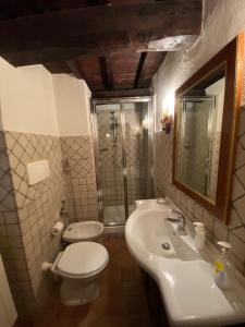 La salle de bains est pourvue d'un lavabo, de toilettes et d'un miroir. dans l'établissement Il borgo di Firenzuola Camere con camino, à Crocemaroggia