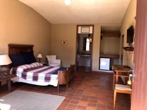 a bedroom with a bed and a television in it at Pousada Condado Santa Maria in Baependi