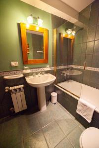 a bathroom with a sink and a toilet and a tub at Hotel Campanilla in Ushuaia