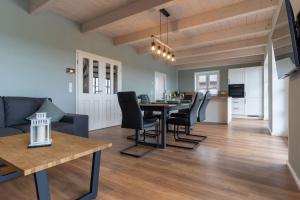 a dining room and living room with a table and chairs at DHH Buhne in Karolinenkoog