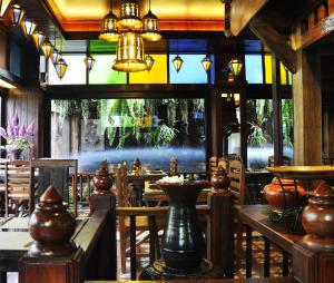 Un restaurante con mesas y una vidriera. en Namton Boutique Hotel, en Chiang Mai