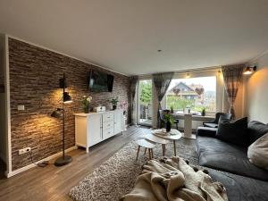 a living room with a couch and a brick wall at Wurmbergblick Nico in Braunlage 4 Sterne zertifiziert vom DTV inklusive Wäschepakete in Braunlage