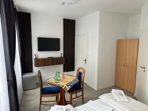 a room with a table and chairs and a television at Hotel-Café-Burg Stahleck in Bacharach