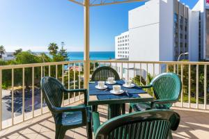 a table and chairs on a balcony with the ocean at Apartamentos Solset Nerja in Nerja