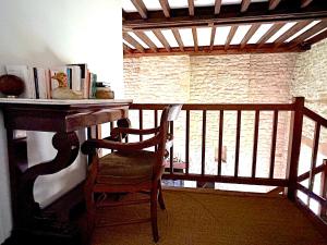 a chair sitting on a balcony with a table and books at Cottage de Keran in Arradon