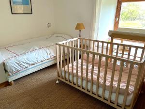 a baby crib in a bedroom with a window at Cottage de Keran in Arradon