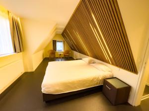 ein Schlafzimmer mit einem weißen Bett und einem Fenster in der Unterkunft Villa Vindina in De Panne