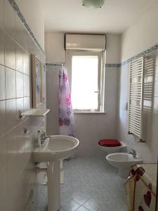La salle de bains est pourvue de 2 lavabos, de toilettes et d'une fenêtre. dans l'établissement La casa al mare di Mary - Bilocale, à Roseto degli Abruzzi