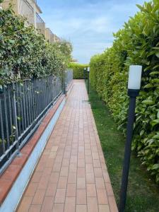 une passerelle en briques avec un compteur de stationnement à côté d'une clôture dans l'établissement La casa al mare di Mary - Bilocale, à Roseto degli Abruzzi