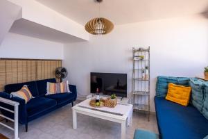 uma sala de estar com dois sofás azuis e uma mesa em EVA Ocean & Cliff Luxury Los Gigantes em Puerto de Santiago