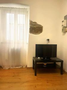 uma sala de estar com televisão numa mesa e uma janela em Piccolo appartamento nel cuore di Trieste em Trieste