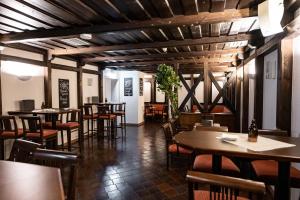 a restaurant with wooden ceilings and tables and chairs at Parkhotel Hirschwang in Reichenau