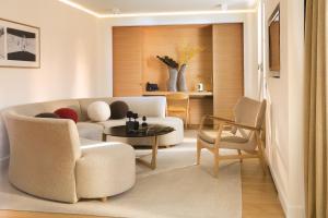 a living room with a couch and a table and chairs at Hotel Marignan Champs-Elysées in Paris