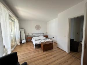 a bedroom with a bed and a wooden floor at Minusio-Locarno Casa al Lago 1 in Minusio