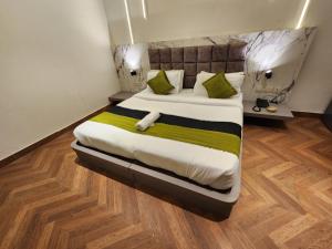 a bedroom with a large bed with green and white pillows at Square9 - A Boutique Hotel in Gurgaon