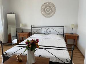 a bedroom with a bed with a vase of flowers on a table at Minusio-Locarno Casa al Lago 1 in Minusio