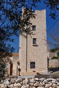 阿里奧波利斯的住宿－Lithos Stone Suites，一座带塔楼的大型石头建筑