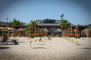 a beach with many umbrellas and chairs and chairs at Oasi Beach Hotel in Vieste