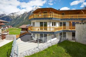 ein Haus mit Balkon und Bergen im Hintergrund in der Unterkunft Alpen Diamond Top 500 in Sölden