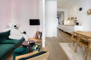 a living room with a teddy bear sitting on a green couch at The 1880 Boutique Holiday Home in Antwerp