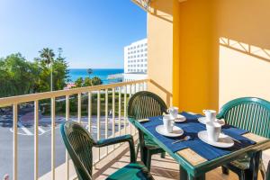 a table and chairs on a balcony with the ocean at Apartamentos Solset Nerja in Nerja