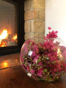 - un bol de fleurs assis sur une table à côté d'une cheminée dans l'établissement Cozy house in collina, à Giovo