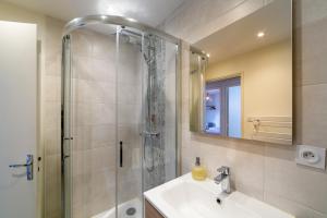 Un baño con ducha, lavabo y espejo. en Happy Loft - Centre historique + parking privé, en Blois 10 fotos más
