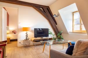 Una sala de estar con una mesa y un televisor. en Happy Loft - Centre historique + parking privé, en Blois