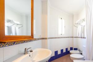 a bathroom with a sink and a toilet and a mirror at Apartamentos Solset Nerja in Nerja