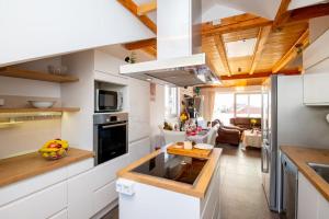 una cocina con armarios blancos y techos de madera. en Chiefs Suite - Kriste, en Dubrovnik