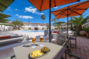 a table with two glasses of wine and a bowl of food at Oassium Hotel - Adults Only in La Pineda