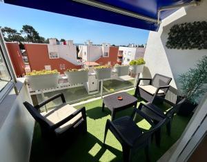 a balcony with chairs and tables and a view of a city at Divine Waves - Cabedelo in Viana do Castelo