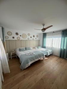 1 dormitorio con 2 camas y ventilador de techo en Casa Rural La Chicuela, 