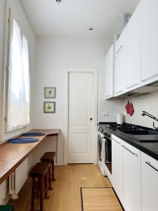 una cucina con armadi bianchi e piano di lavoro di Koro's Apartments a Bologna