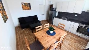 uma cozinha e sala de jantar com mesa e cadeiras em Apartmány Boule em Kovářská