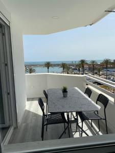 a table and chairs on a balcony with a view of the ocean at Apartamento Fuengirola Puerto in Fuengirola
