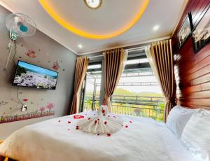 een slaapkamer met een wit bed met rozen erop bij Pine Forest House Dalat in Xuan An