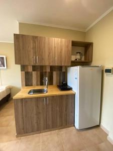 a kitchen with a sink and a refrigerator at Los Jacintos Villa Sarita Posadas - 1A in Posadas